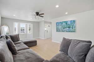 Living room with light wood-type flooring, recessed lighting, and a ceiling fan