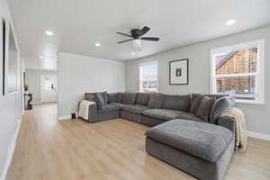 Living area with healthy amount of natural light, a ceiling fan, light wood-type flooring, and recessed lighting