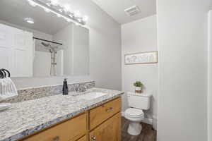 Bathroom featuring vanity, dark wood-type flooring, and a shower