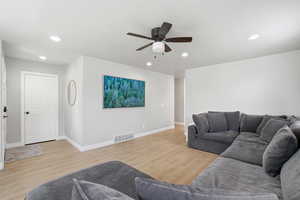 Living area featuring light wood-style flooring, recessed lighting, and a ceiling fan