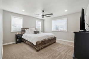 Bedroom with light carpet, ceiling fan, and recessed lighting