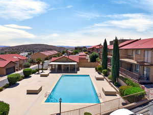 Community pool with a patio area, a residential view, and a mountain view