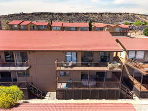 Rear view of house featuring a tile roof and stairway
