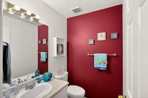 Half bathroom with vanity and a textured ceiling