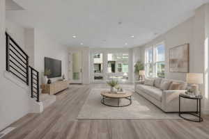 Spacious living area featuring wood-finish flooring, recessed lighting, and large windows