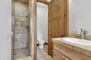 Bathroom featuring a shower stall, vanity, and light tile patterned floors