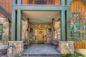 Entrance to property featuring stone siding and a ceiling fan