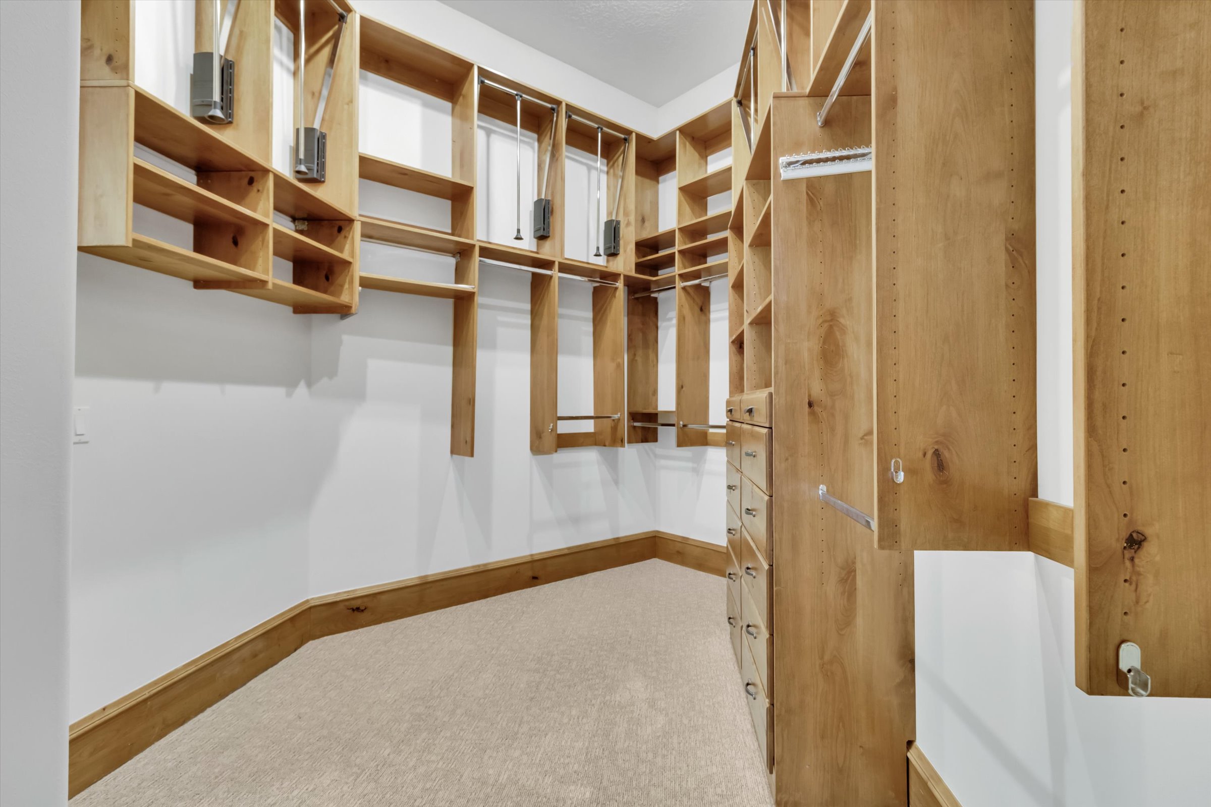 Owner’s suite walk-in closet features custom dual-tiered closet system.