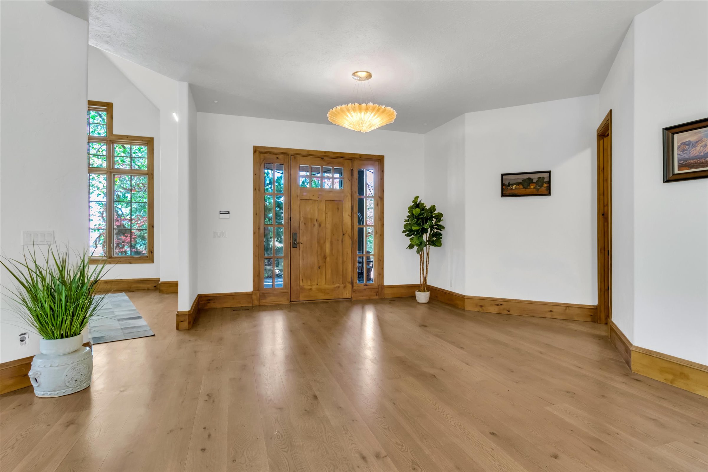 Large, open foyer with custom millwork and white oak flooring.