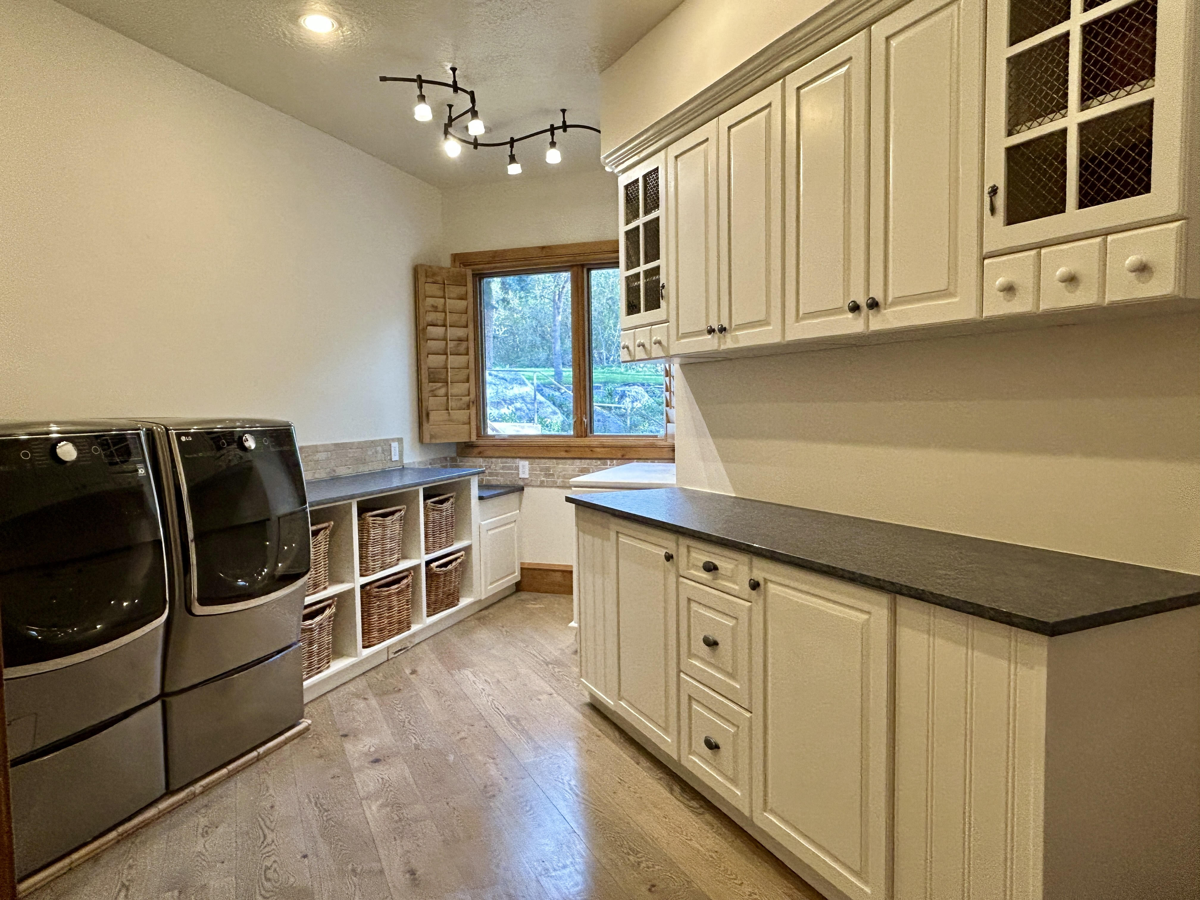 Laundry room with custom cabinetry and high end appliances.