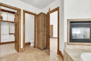 Full bath featuring stone tile floors and a bath