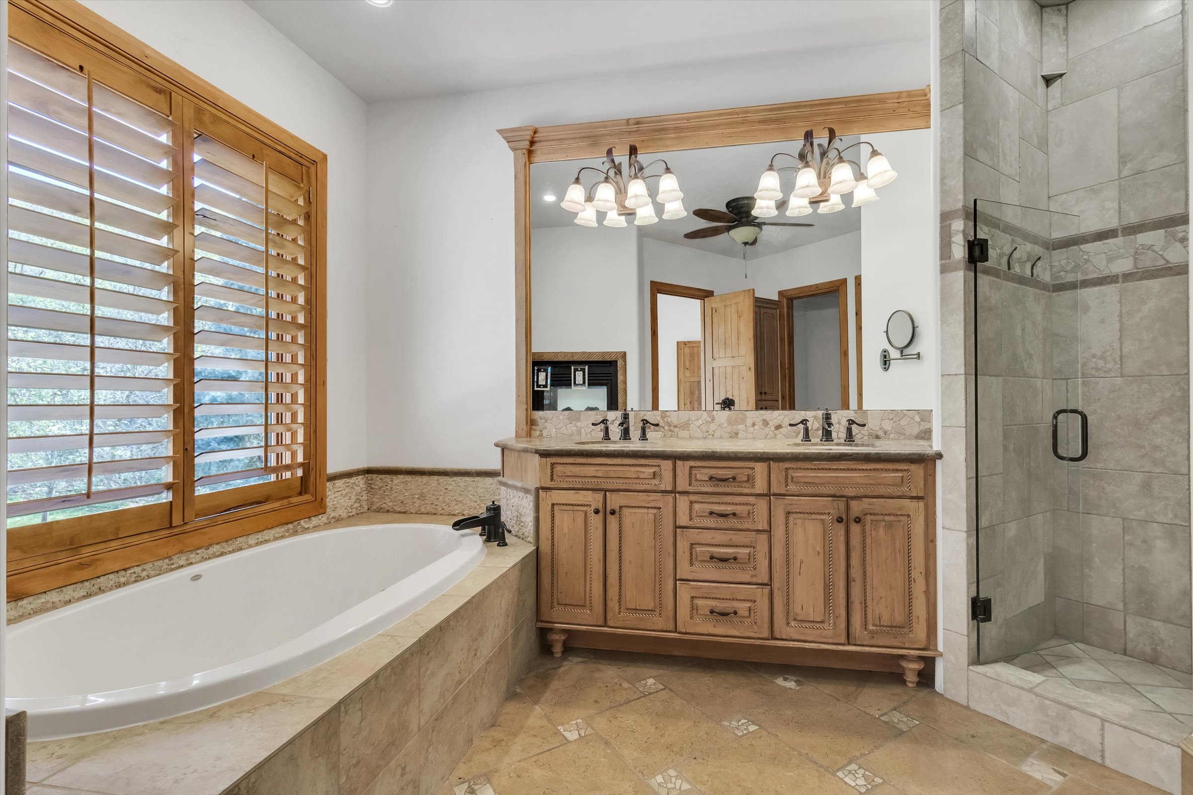En suite bath featuring jetted garden tub, fireplace, and large shower.