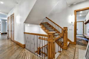 Staircase with wood finished floors and recessed lighting
