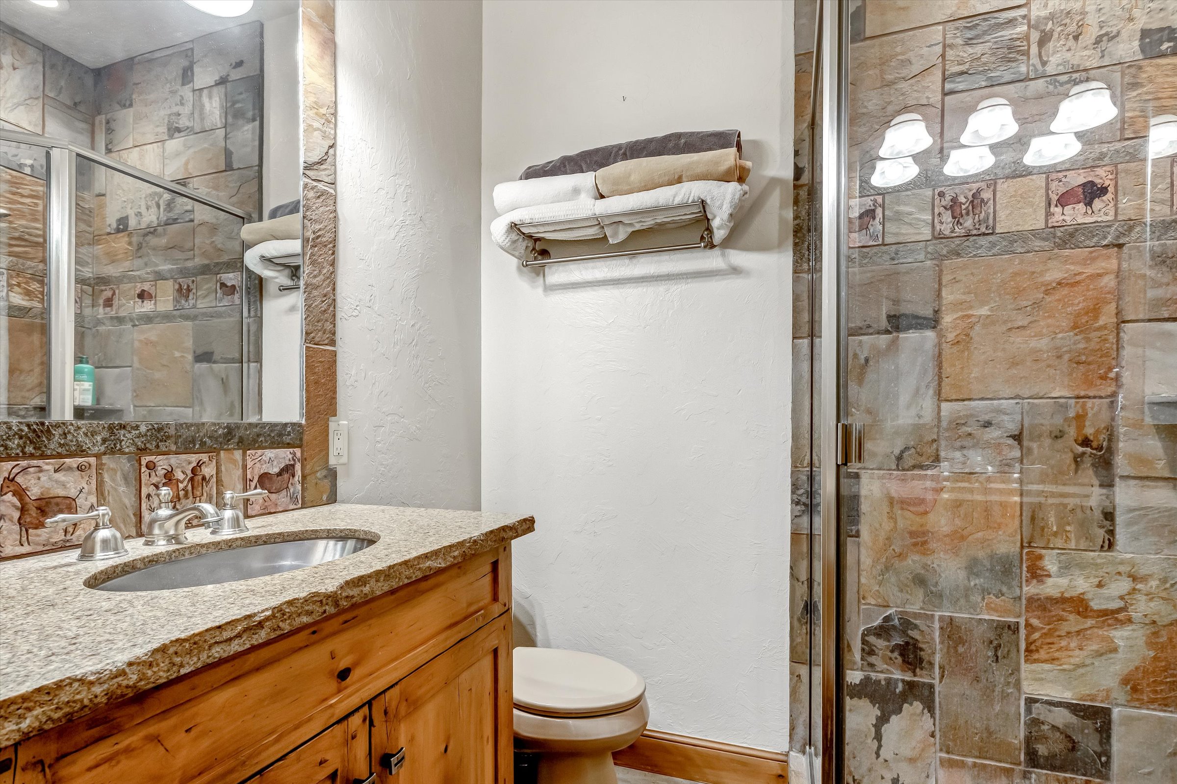 ¾ bath with granite countertop and slate shower surround.