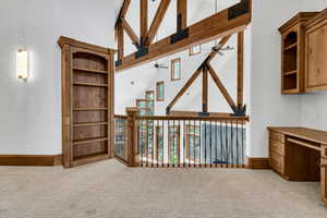 Office space with light colored carpet and lofted ceiling