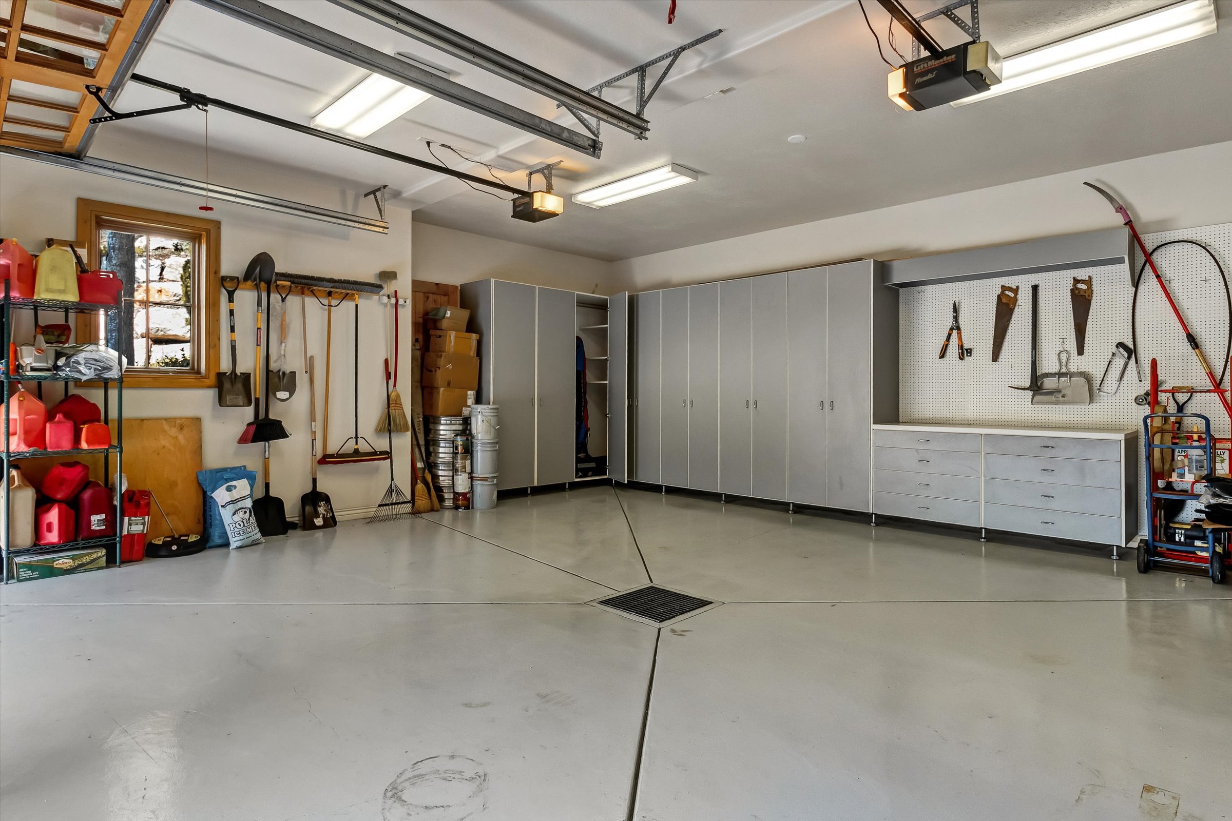 Heated garages feature floor drains, hot water with hose hookup, epoxy floors, and cabinetry.