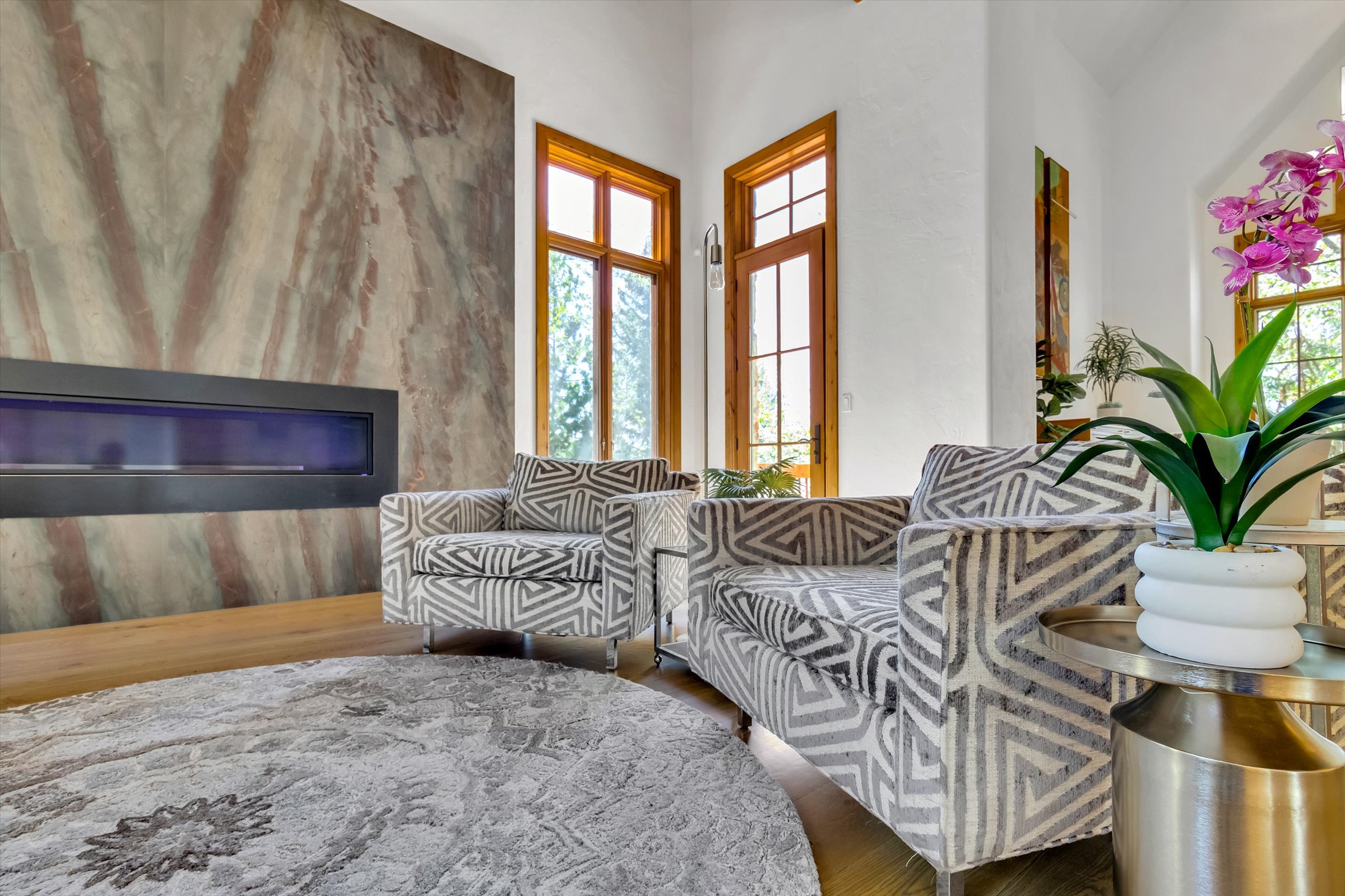 Welcoming linear fireplace and leathered marble surround.