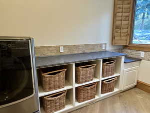 Detailed view of washer / dryer and wood finished floors