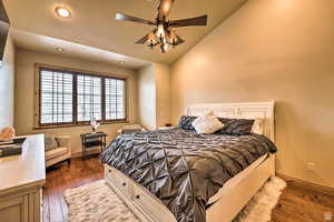 Bedroom with dark wood-style flooring, lofted ceiling, a ceiling fan, and recessed lighting