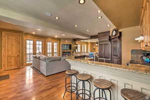 Kitchen with a kitchen breakfast bar, light stone countertops, recessed lighting, extractor fan, and a peninsula