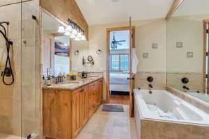 Full bathroom with ensuite bathroom, double vanity, light tile patterned floors, a tub with jets, and a shower stall