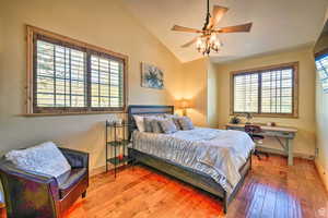 Bedroom with wood-type flooring, vaulted ceiling, and a ceiling fan