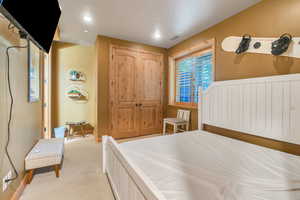 Bedroom with light carpet and a closet