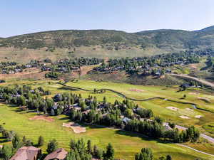 Aerial overview of property's location with a golf course and nearby suburban area