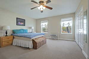 Bedroom featuring a closet, light carpet, and ceiling fan