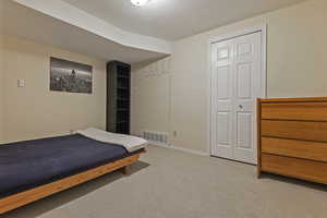 Bedroom featuring light colored carpet and a closet