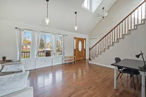Entrance foyer with plenty of natural light, a skylight, dark wood finished floors, and lofted ceiling