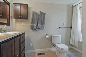 Bathroom with vanity, shower / bath combination with curtain, and light tile patterned floors