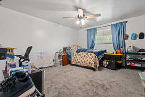 Primary bedroom with carpet and ceiling fan