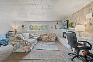 Office space featuring a stone fireplace and carpet