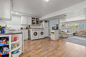Laundry area featuring light wood finished floors and separate washer and dryer