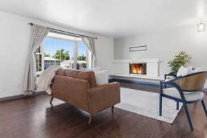 Bright living area featuring wood-finish flooring, a contemporary fireplace, and a large bay window