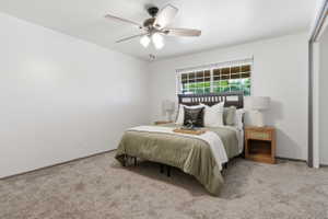 Carpeted room featuring a ceiling fan with light fixture, a window with horizontal blinds, and a built-in closet with sliding doors