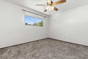 Room featuring neutral-toned walls, gray carpet flooring, and a ceiling fan with wood-finish blades and integrated lighting