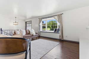 Spacious living area featuring wood-finish flooring and a prominent bay window
