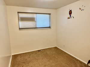 Empty room featuring carpet floors and baseboards