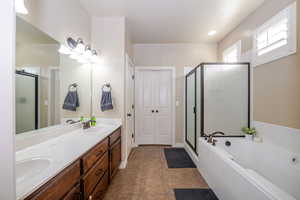 Primary Bathroom with double sinks, separate tub/shower, and walk-in closet