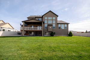 Back of house with covered deck, patio, and fully fenced backyard