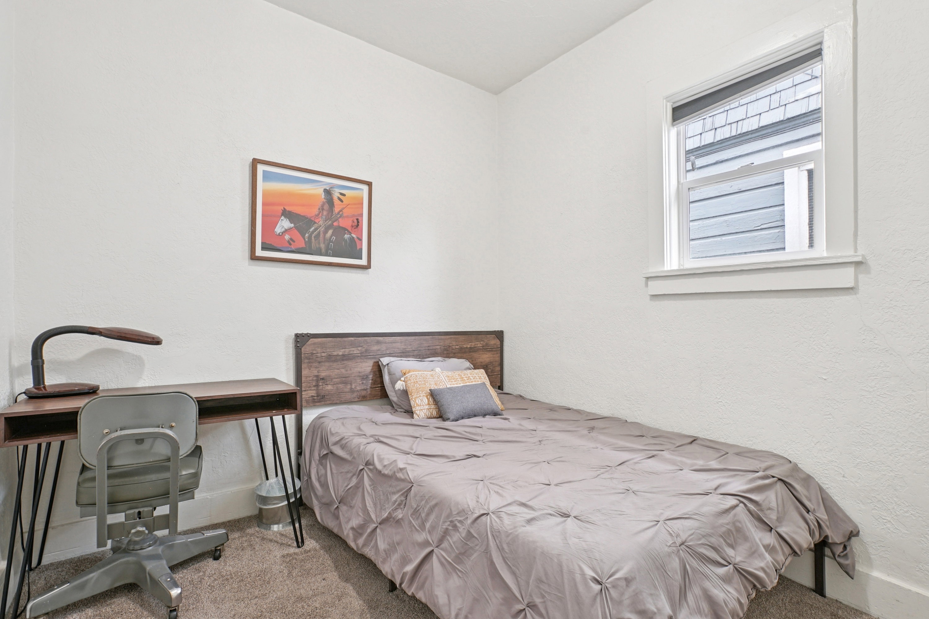 Carpeted bedroom featuring a textured wall and baseboards