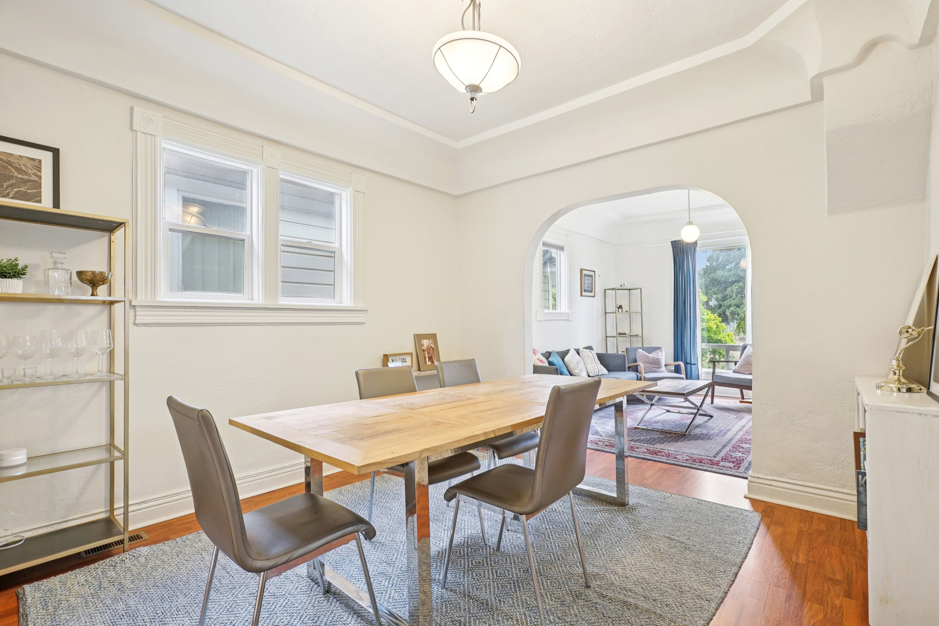 Dining area with arched walkways and dark wood-style flooring