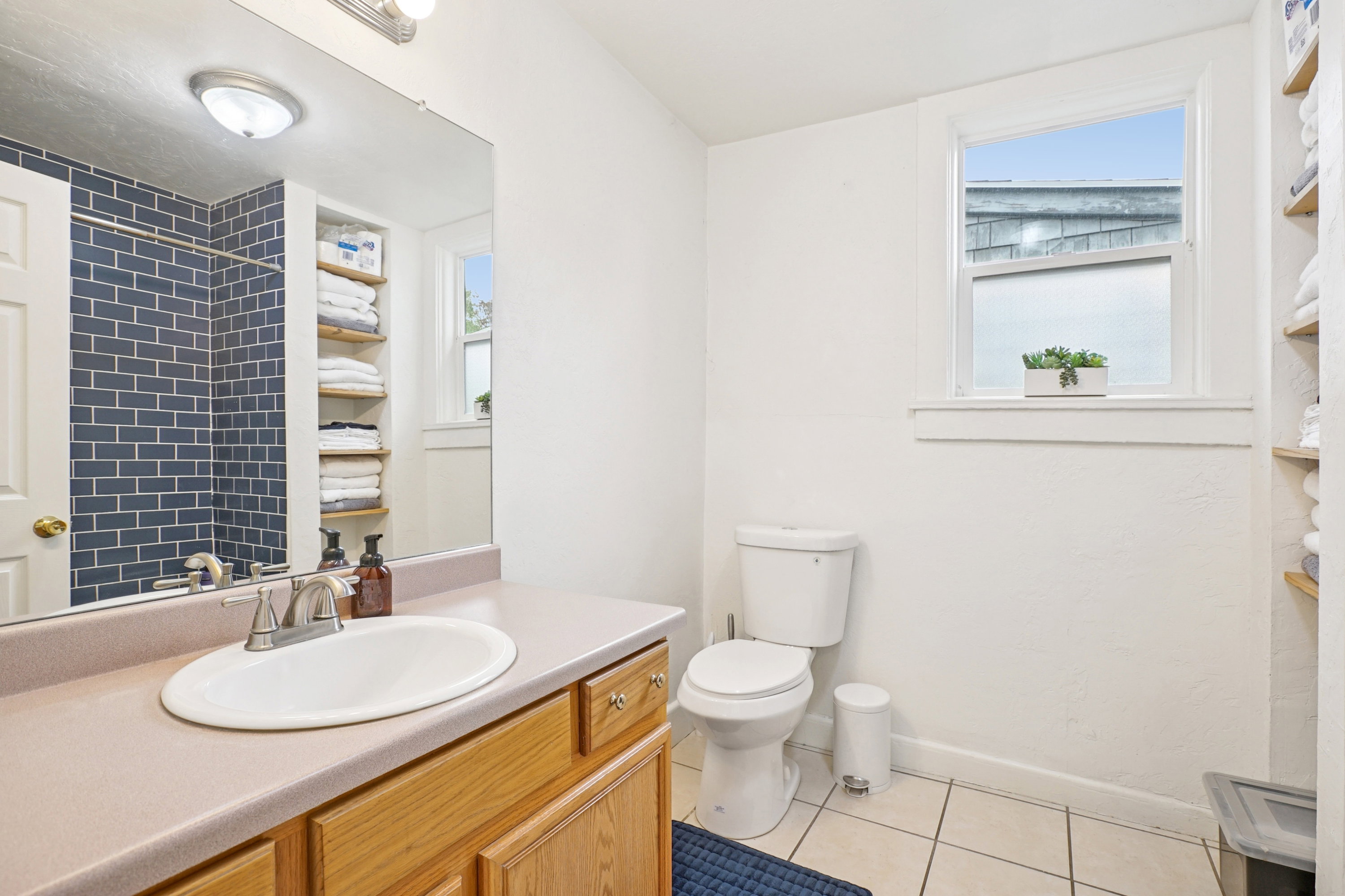 Full bathroom featuring light tile patterned floors, vanity, and a shower