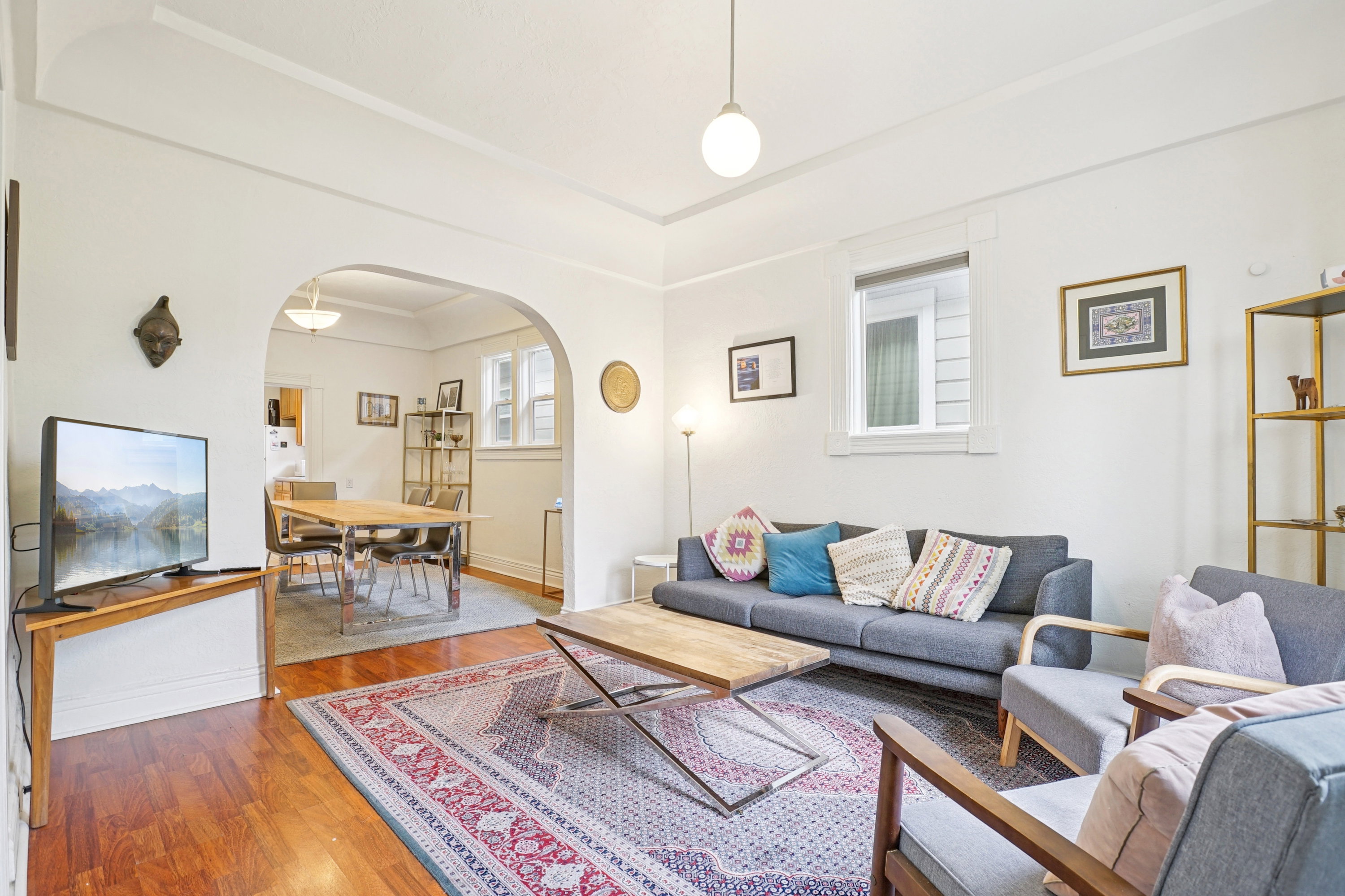 Living area with hardwood / wood-style flooring and arched walkways