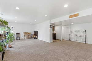 Living area with light colored carpet and recessed lighting