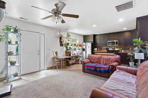 Living area featuring a ceiling fan, recessed lighting, and light tile patterned flooring