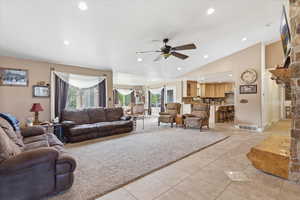 Living area featuring ceiling fan, healthy amount of natural light, vaulted ceiling, recessed lighting, and light tile patterned floors