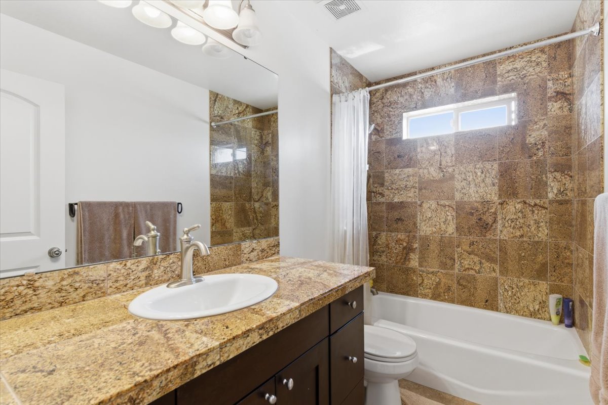 Full bath featuring vanity and shower / bath combo